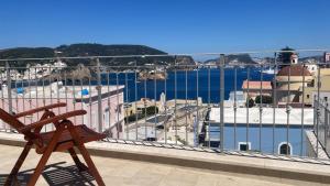 a wooden bench sitting on top of a balcony overlooking a harbor at La Parata in Ponza