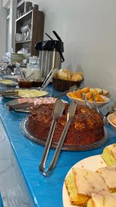 a table topped with different types of cakes and pies at Hotel Polonini in Piúma