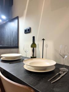 a table with two white plates and a bottle of wine at ŌMNIMI Signature Living in Skala Potamias +38 photos
