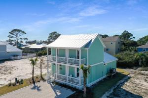 a house on the beach with palm trees at Keys to the Cape by Pristine Properties Vacation Rentals in Cape San Blas
