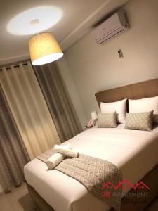 a bedroom with two beds and a light at JB Apartment -B18- in Kenitra