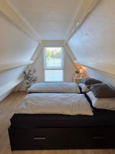 two beds in a room with an attic at View at the Lake in Nieuwe-Niedorp