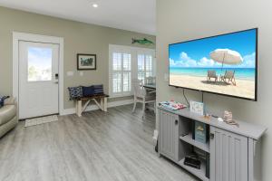 a living room with a flat screen tv on a wall at Lala's Place by Pristine Properties Vacation Rentals in Mexico Beach
