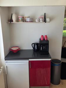a small kitchen with a black counter top and a microwave at View at the Lake in Nieuwe-Niedorp +14 photos