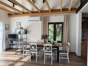 a dining room with a wooden table and chairs at Hotel Cider&Squash garden haus, Grncarska 6, Prnjavor in Prnjavor