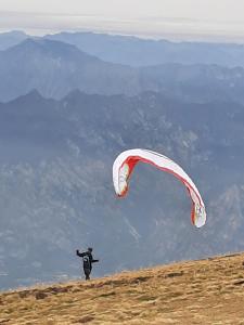 a person flying a kite on top of a hill at la terrazza del borgo con parcheggio in Malcesine