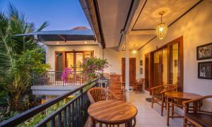 a balcony with wooden tables and chairs at Pondok Taksu Bali in Kuta