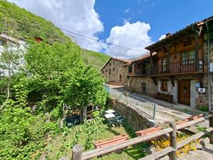 a group of buildings on a hill next to a street at Casa Rural La Torre de Espinama in Espinama