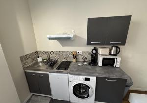 a kitchen with a washing machine and a sink at Duplex Royal Château Compiègne in Compiègne