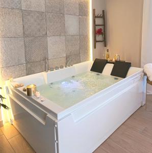 a bath tub filled with water in a bathroom at Ciatu Miu Spa Suite Gambino in Carini