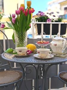 a table with a vase of flowers and tea cups at Ciatu Miu Spa Suite Gambino in Carini