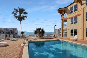 a swimming pool in front of a building with the ocean at Summerhouse 106 by Pristine Properties Vacation Rentals in Mexico Beach