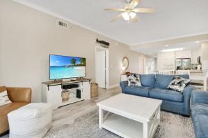 a living room with a blue couch and a tv at Summerhouse 106 by Pristine Properties Vacation Rentals in Mexico Beach