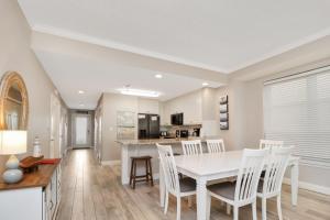 a kitchen and dining room with a white table and chairs at Summerhouse 106 by Pristine Properties Vacation Rentals in Mexico Beach