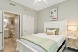 a white bedroom with a bed and a bathroom at Summerhouse 106 by Pristine Properties Vacation Rentals in Mexico Beach +40 photos