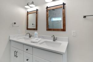 a bathroom with two sinks and two mirrors at Beach Fantasies B by Pristine Properties Vacation Rentals in Mexico Beach +50 photos