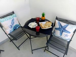 a black table with a plate of bread and two chairs at As Praias in Sesimbra +72 photos