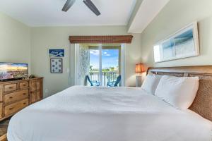 a bedroom with a white bed and a balcony at Summerhouse 101 - Pearl of the Gulf by Pristine Properties Vacation Rentals in Mexico Beach +46 photos