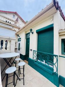 a balcony with a table and chairs on a building at Maisonnette au calme-proche Métro in Maisons-Alfort
