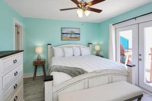 a bedroom with a white bed and a ceiling fan at Edgewater Retreat by Pristine Properties Vacation Rentals in Cape San Blas