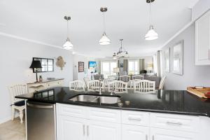 a kitchen with a sink and a dining room at Pelican Crossing by Pristine Properties Vacation Rentals in Cape San Blas