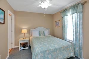a bedroom with a bed with a blue comforter and a window at Pelican Landing 3 by Pristine Properties Vacation Rentals in Indian Pass