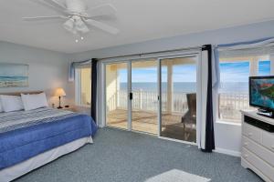 a bedroom with a bed and a television and a balcony at Pelican Landing 3 by Pristine Properties Vacation Rentals in Indian Pass