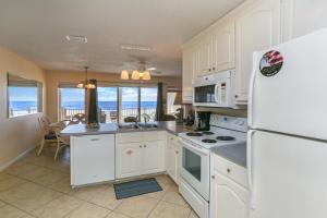 a kitchen with white appliances and a view of the ocean at Pelican Landing 2 by Pristine Properties Vacation Rentals in Indian Pass