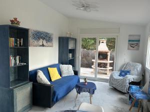 a living room with a blue couch and a chair at Villa Casa rosa Maria in Platja d'Aro
