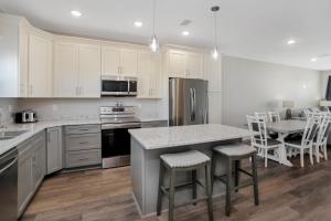 a kitchen with white cabinets and a island with bar stools at Pelican's Perch by Pristine Properties Vacation Rentals in Saint Joe Beach