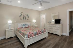 a bedroom with a bed and two night stands and a tv at Pelican's Perch by Pristine Properties Vacation Rentals in Saint Joe Beach