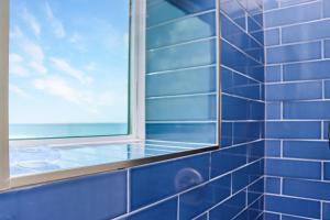 a blue tiled bathroom with a window at Sea La Vie by Pristine Properties Vacation Rentals in Mexico Beach +72 photos