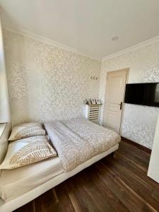 a bedroom with a bed and a wall with wallpaper at Maisonnette au calme-proche Métro in Maisons-Alfort