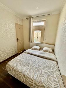 a bedroom with a large bed with a window at Maisonnette au calme-proche Métro in Maisons-Alfort +11 photos