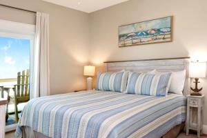 a bedroom with a bed with blue and white stripes at The Great White 1 by Pristine Properties Vacation Rentals in Beacon Hill
