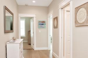 a white room with a mirror and a white hallway at The Great White 1 by Pristine Properties Vacation Rentals in Beacon Hill +46 photos