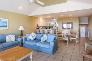 a living room with blue couches and a kitchen at A New Beginning by Pristine Properties Vacation Rentals in Indian Pass