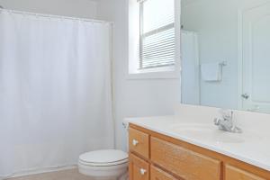 a bathroom with a toilet and a sink and a mirror at Flamingo Dunes by Pristine Properties Vacation Rentals in Saint Joe Beach +36 photos