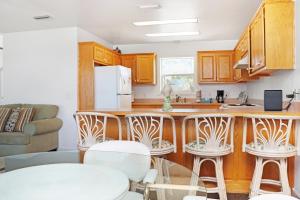 a kitchen with wooden cabinets and white stools at Flamingo Dunes by Pristine Properties Vacation Rentals in Saint Joe Beach