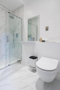 a white bathroom with a toilet and a shower at Stylish 2BR Flat by Richmond Park in Kingston upon Thames +38 photos