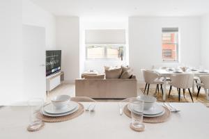 a white living room with a table and a couch at Stylish 2BR Flat by Richmond Park in Kingston upon Thames
