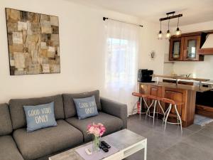 a living room with a couch and a kitchen at Ferienwohnung KRK Peter Lindpointner in Krk