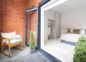 a bedroom with a brick wall and a bed at Stylish 2BR Flat by Richmond Park in Kingston upon Thames