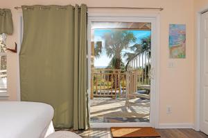 a bedroom with a door open to a patio with a porch at Gulfside GEM by Pristine Properties Vacation Rentals in Indian Pass +58 photos