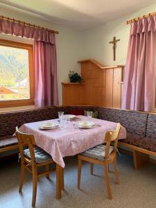 a table with two chairs and a couch with a cross at Ferienwohnung Frieda in Sillian +14 photos