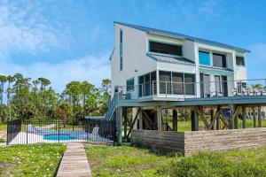 a white house with a deck and a pool at Indian Summer by Pristine Properties Vacation Rentals in Indian Pass