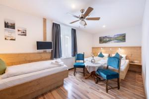 a bedroom with two beds and a table and chairs at Hotel Gisela in Kufstein