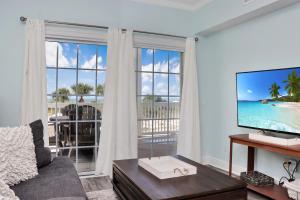 a living room with a tv and a large window at Dunes Club 1A by Pristine Properties Vacation Rentals in Cape San Blas