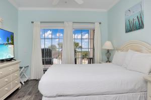 a bedroom with a large white bed and a window at Dunes Club 1A by Pristine Properties Vacation Rentals in Cape San Blas +30 photos