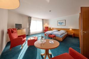 a hotel room with a bed and a table and chairs at Aparthotel Kachelot in Borkum